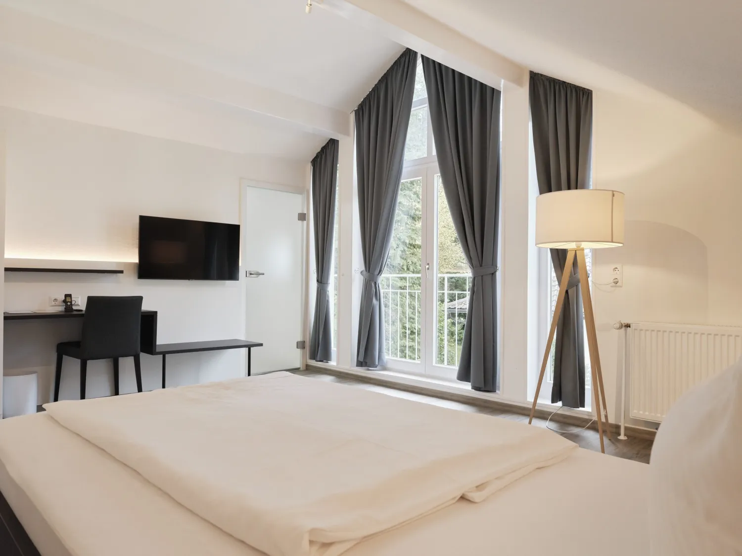 Doppelzimmer mit Wand-TV und hoher Fensterfront