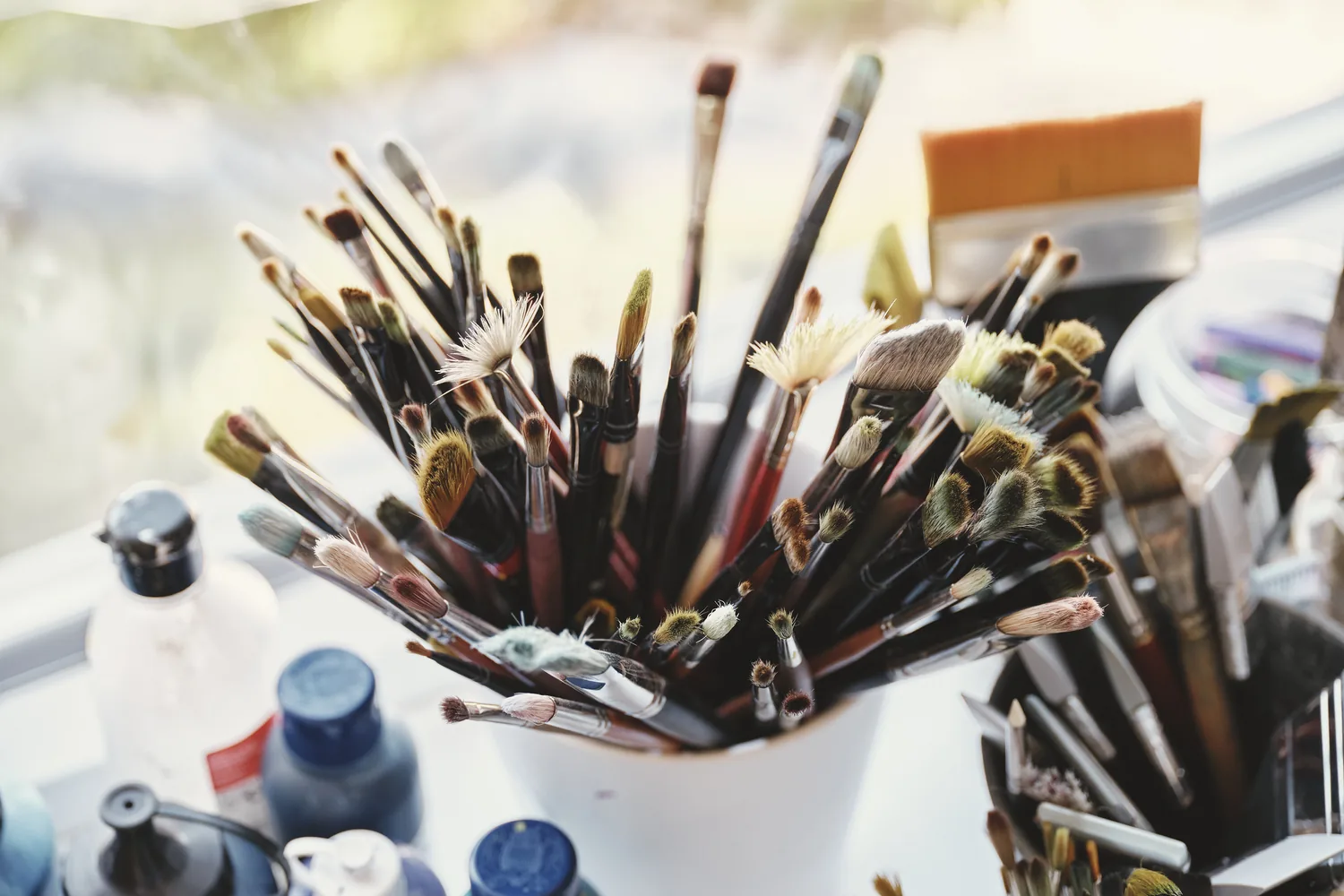 Becher voller Pinsel im Atelier der Kunsttherapie