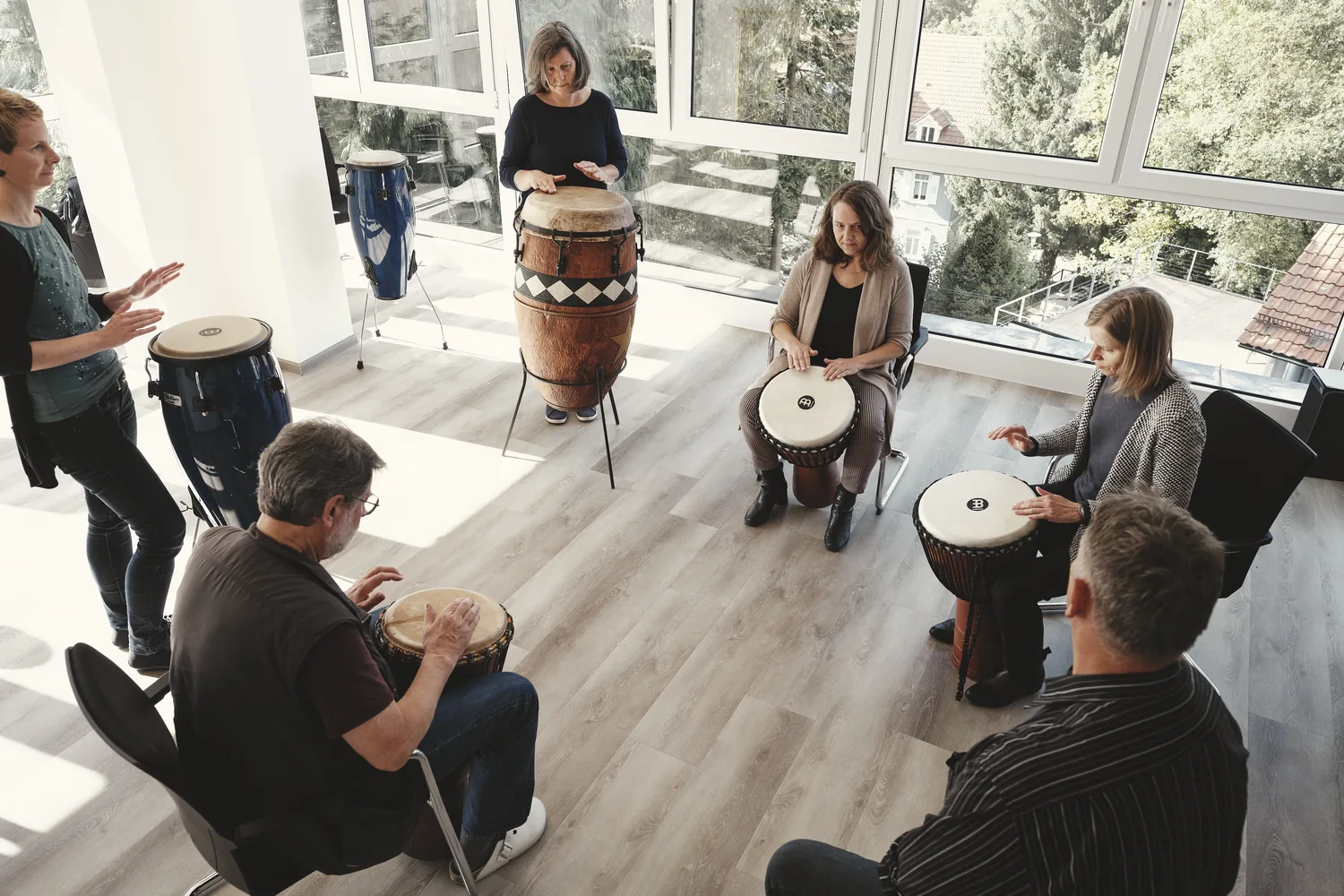 Gruppe im Trommelkreis mit Djemben in der Musiktherapie